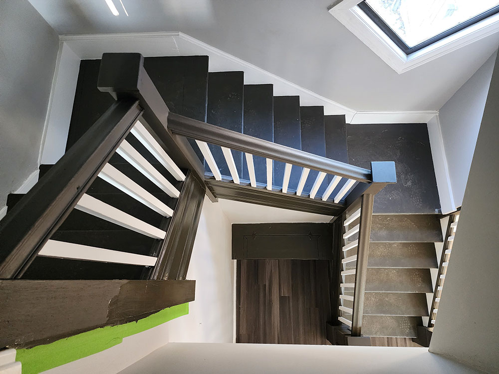 A stairway illuminated by a skylight above, creating a bright and inviting atmosphere.