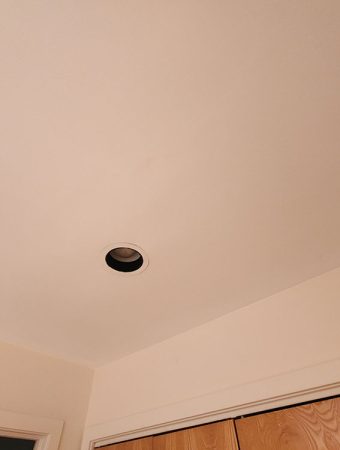 Ceiling with a decorative light fixture hanging from it, illuminating the space below.