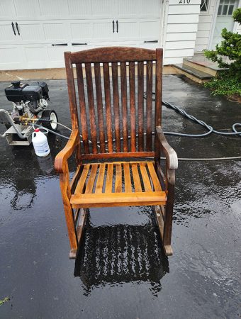 A simple wooden chair placed on the ground, showcasing its natural finish and sturdy design.